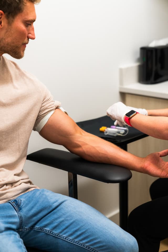 A clinician prepares a patient's arm for a blood draw