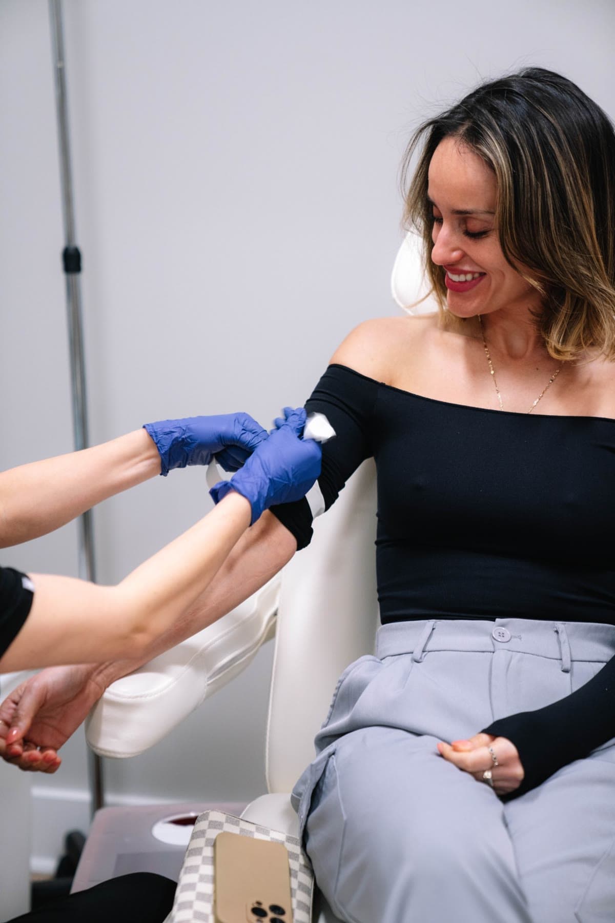 A smiling patient as a clinician finishes her blood draw