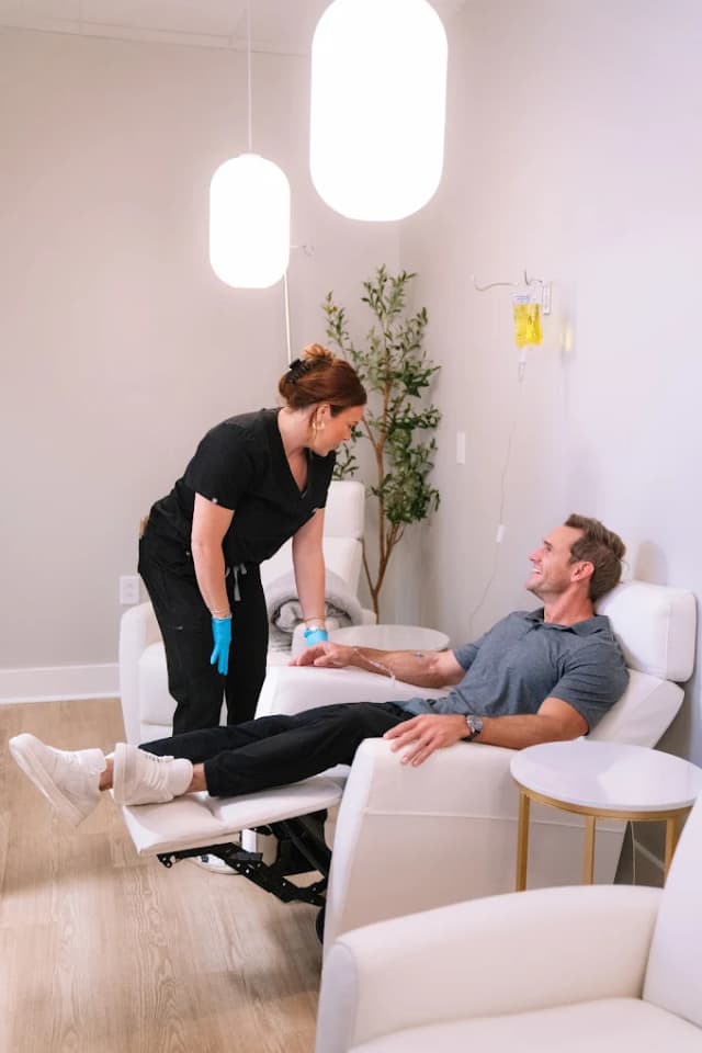 A clinician cares for a patient during an IV infusion