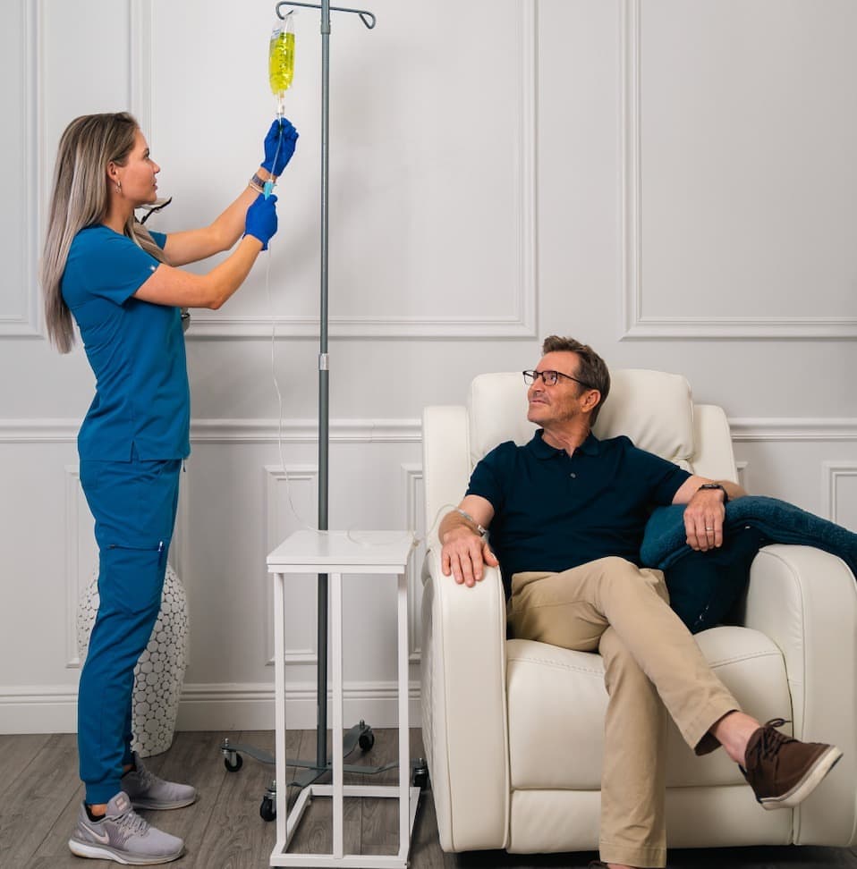 A Relive nurse hangs a vitamin IV for a relaxed patient at Relive Health Stuart